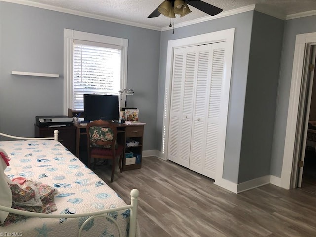 bedroom with ceiling fan, dark hardwood / wood-style flooring, ornamental molding, and a closet