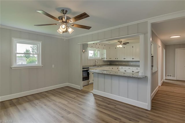 4249 High Point Rd, Winston-Salem, NC 27107 - kitchen with ornamental molding, a peninsula, light wood finished floors, ceiling fan, and a decorative wall