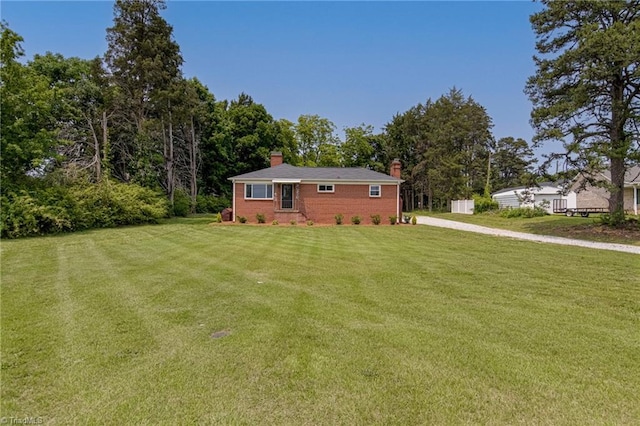 4249 High Point Rd, Winston-Salem, NC 27107 - view of front of home featuring a chimney, a front lawn, brick siding, and driveway