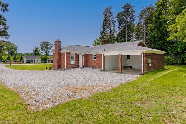 4249 High Point Rd, Winston-Salem, NC 27107 - view of front of property with gravel driveway, a chimney, a front lawn, and an attached carport