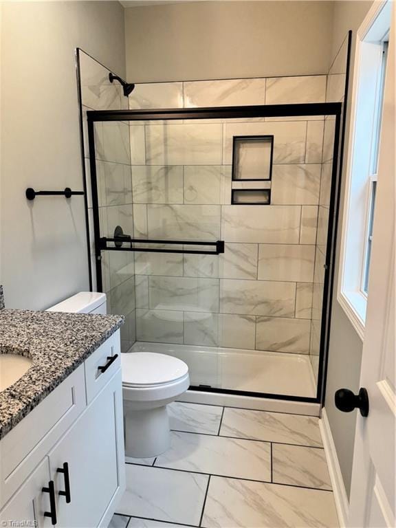 bathroom with vanity, toilet, and a shower with shower door