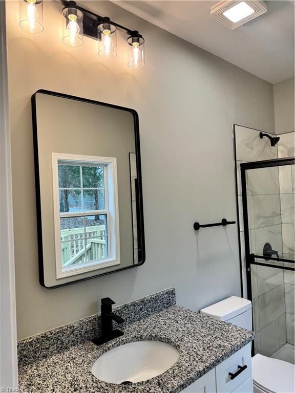 bathroom featuring vanity, toilet, and an enclosed shower