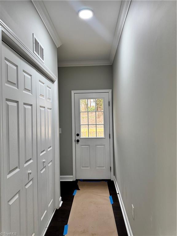 entryway featuring ornamental molding and dark hardwood / wood-style floors