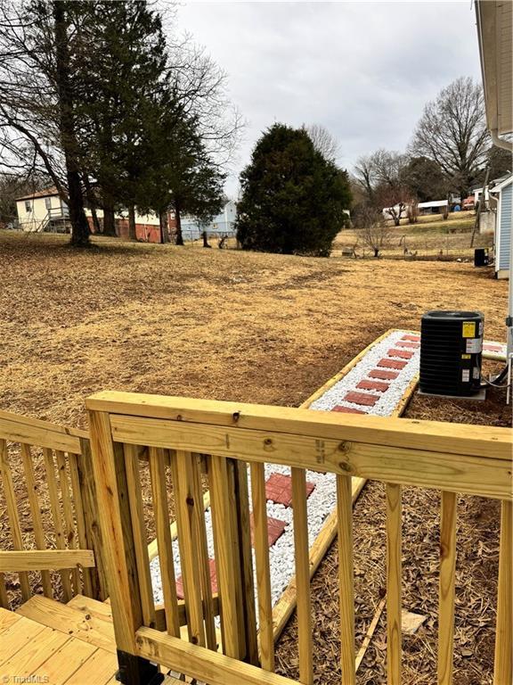 view of yard with a wooden deck and central AC unit