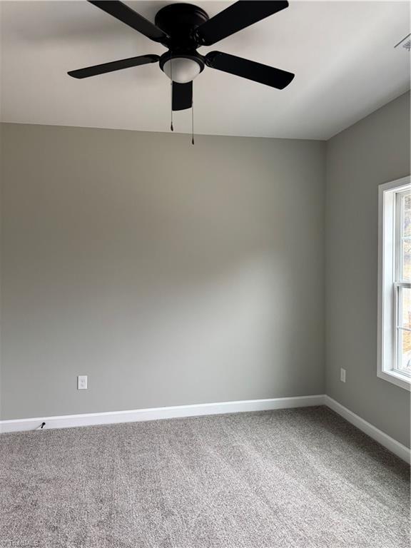 carpeted spare room with ceiling fan