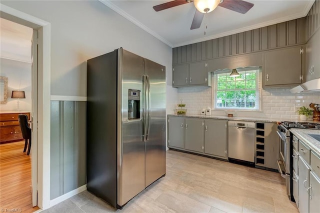 kitchen with appliances with stainless steel finishes, gray cabinets, ornamental molding, a ceiling fan, and decorative backsplash