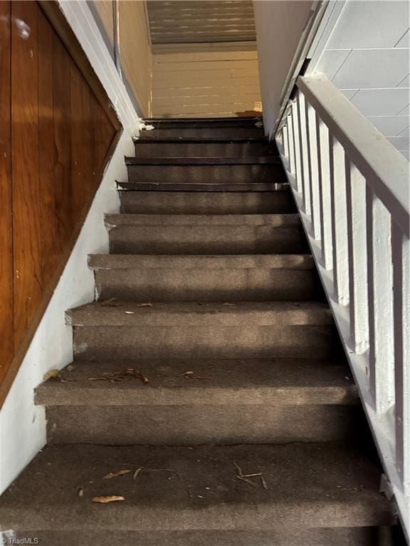 staircase with wood walls