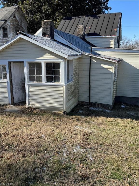 rear view of house featuring a yard