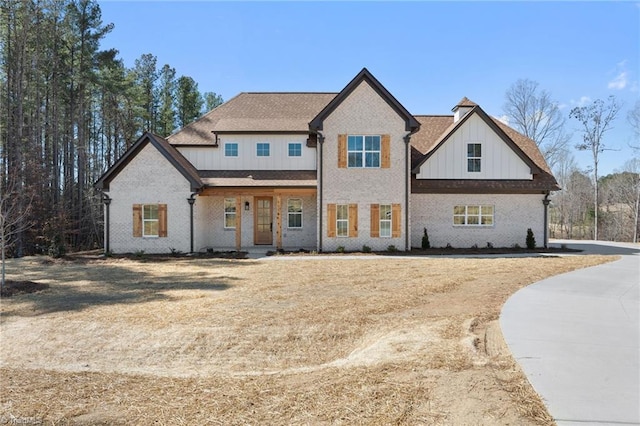 modern farmhouse style home with brick siding and board and batten siding