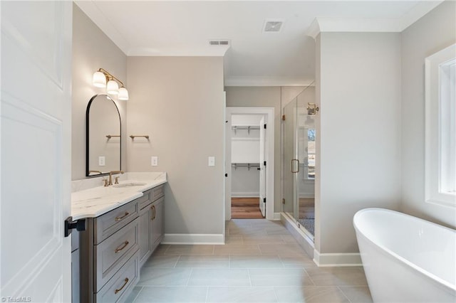 bathroom featuring visible vents, a freestanding bath, a shower stall, and crown molding