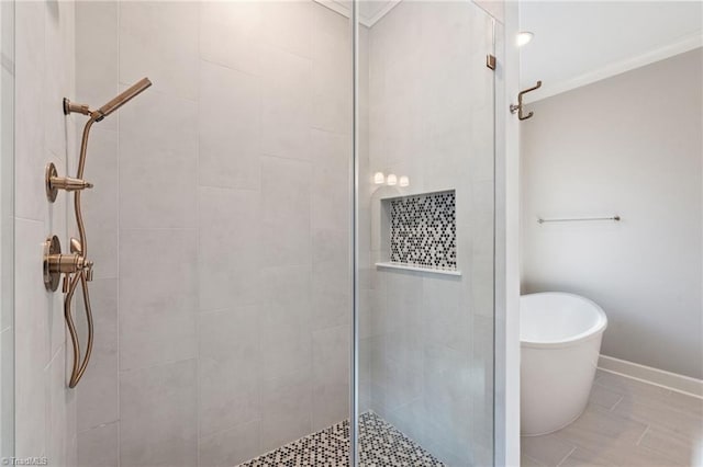 bathroom featuring baseboards, a soaking tub, a stall shower, and ornamental molding