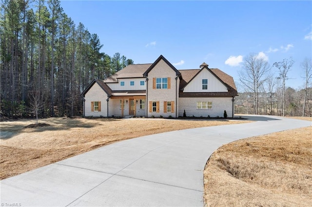 modern farmhouse featuring a front yard, board and batten siding, and driveway