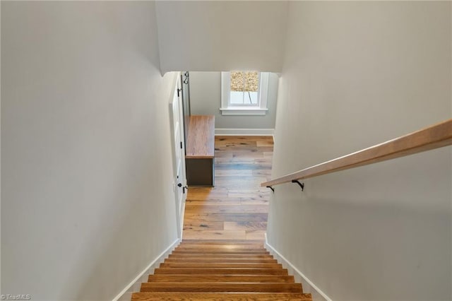 stairs featuring wood finished floors and baseboards