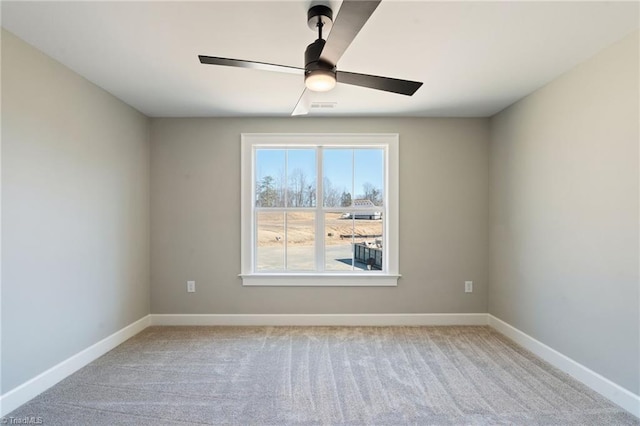 spare room with visible vents, baseboards, and light carpet