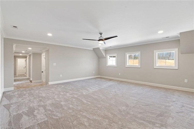 empty room featuring light carpet, recessed lighting, crown molding, and baseboards