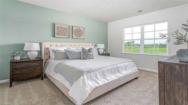 bedroom featuring visible vents, light carpet, and baseboards