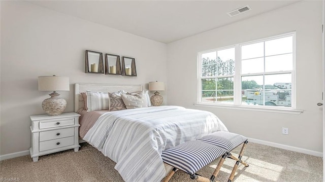 bedroom featuring baseboards, visible vents, and light colored carpet