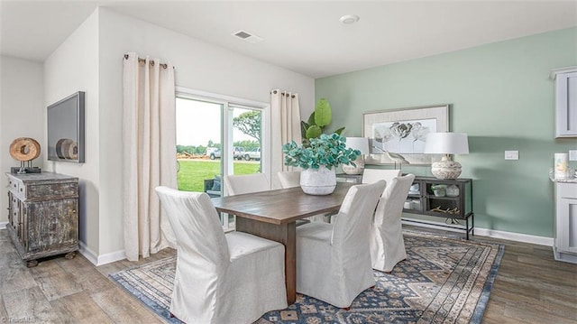 dining space with light wood-style floors, visible vents, and baseboards