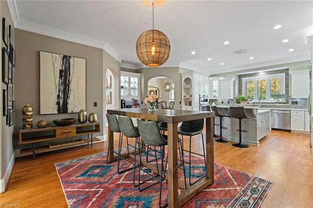 dining room with light hardwood / wood-style flooring, ornamental molding, and plenty of natural light