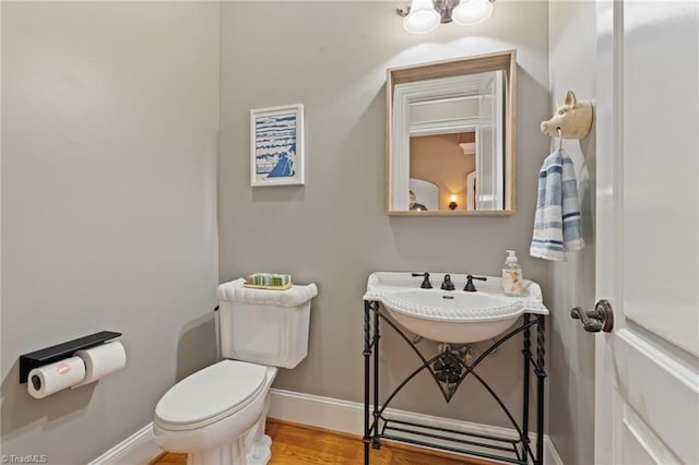 bathroom featuring sink, wood-type flooring, and toilet