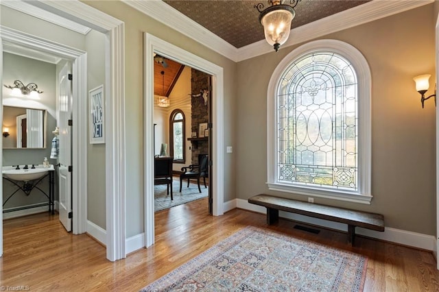 entryway featuring hardwood / wood-style flooring, a healthy amount of sunlight, and ornamental molding