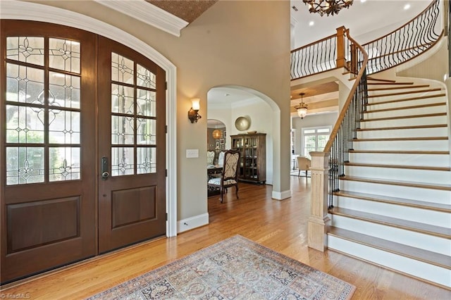 foyer with crown molding, french doors, and light hardwood / wood-style floors