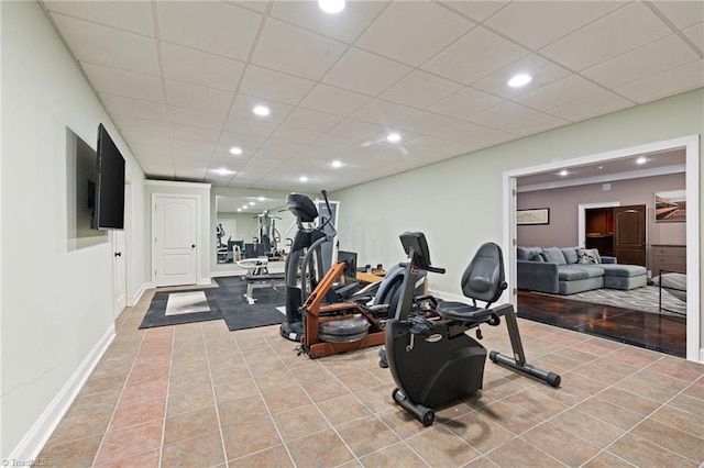 workout area featuring a paneled ceiling and tile patterned flooring