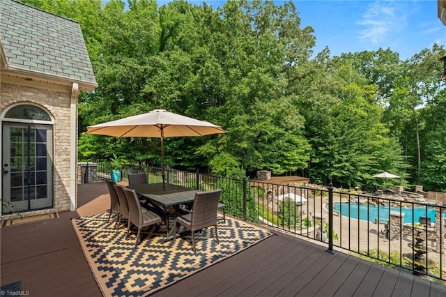 wooden deck with a fenced in pool