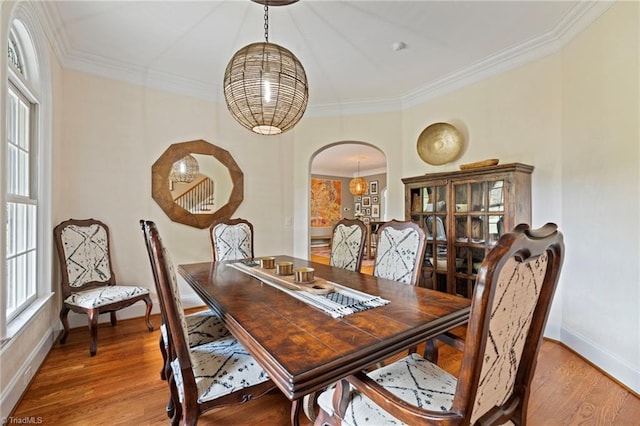 dining area with hardwood / wood-style flooring and ornamental molding