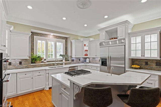 kitchen with sink, a kitchen island, backsplash, and stainless steel appliances