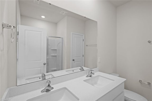 bathroom featuring a sink, toilet, a stall shower, and double vanity