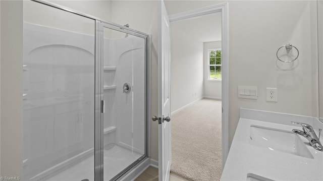 full bathroom with vanity, a shower stall, and baseboards