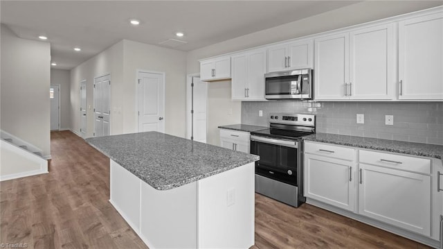 kitchen with a kitchen island, dark wood-type flooring, appliances with stainless steel finishes, and white cabinets