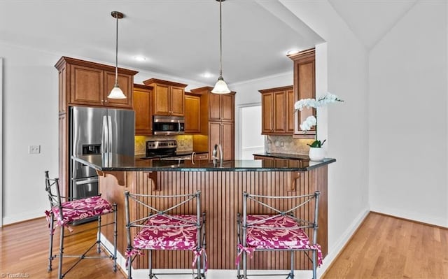 7103 Ludgate Rd, Gibsonville, NC 27249 - kitchen with stainless steel appliances, brown cabinetry, tasteful backsplash, a breakfast bar, and recessed lighting