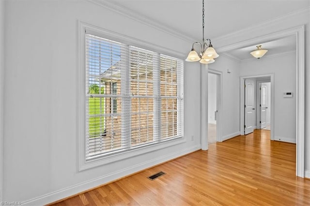 7103 Ludgate Rd, Gibsonville, NC 27249 - unfurnished dining area featuring light wood finished floors, a chandelier, healthy amount of natural light, and crown molding