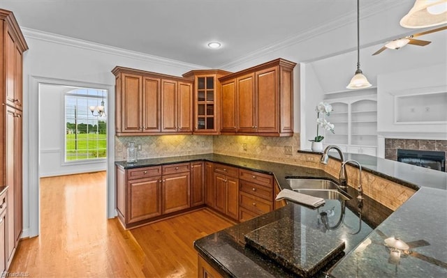 7103 Ludgate Rd, Gibsonville, NC 27249 - kitchen featuring brown cabinets, decorative light fixtures, light wood finished floors, ornamental molding, and recessed lighting