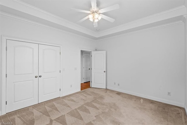 7103 Ludgate Rd, Gibsonville, NC 27249 - unfurnished bedroom featuring carpet floors, ornamental molding, a closet, a tray ceiling, and ceiling fan
