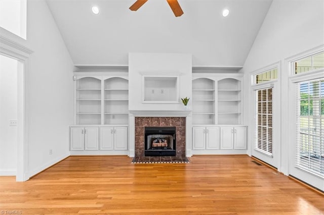 7103 Ludgate Rd, Gibsonville, NC 27249 - unfurnished living room featuring lofted ceiling, ceiling fan, light wood-type flooring, a tiled fireplace, and recessed lighting