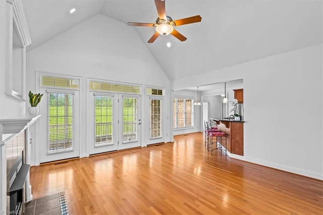 7103 Ludgate Rd, Gibsonville, NC 27249 - unfurnished living room featuring high vaulted ceiling, ceiling fan, plenty of natural light, a fireplace with flush hearth, and light wood finished floors