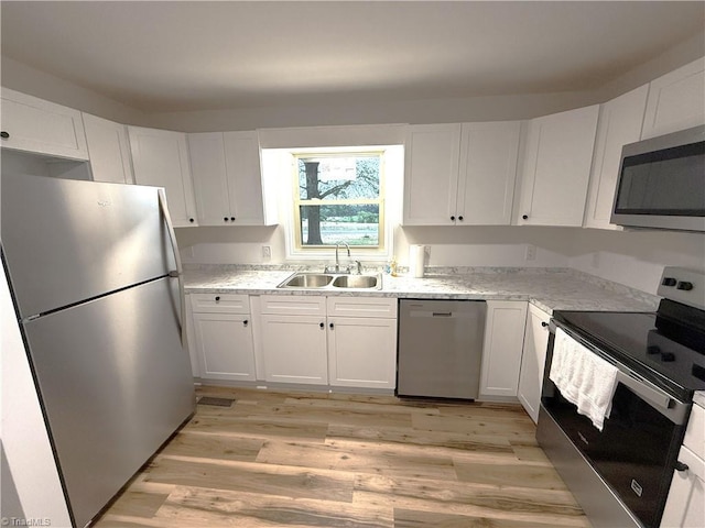 856 Haynes Rd, Elkin, NC 28621 - kitchen featuring appliances with stainless steel finishes, a sink, light wood-style floors, and white cabinets