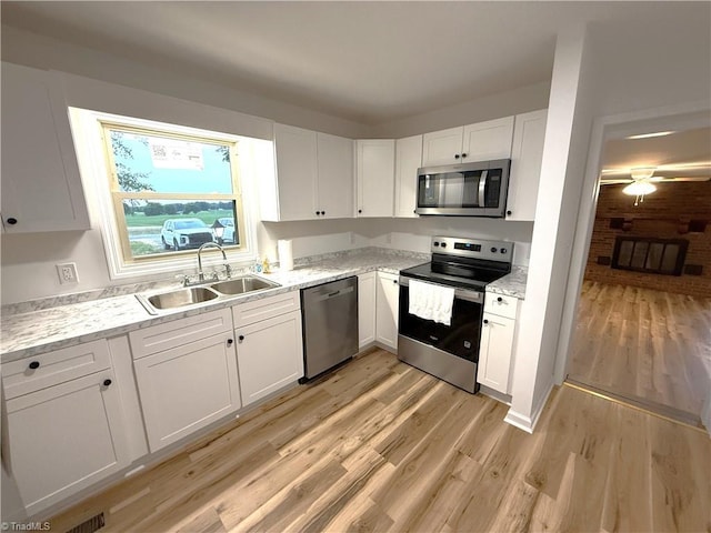 856 Haynes Rd, Elkin, NC 28621 - kitchen featuring stainless steel appliances, a sink, white cabinets, light wood-style floors, and light stone counters
