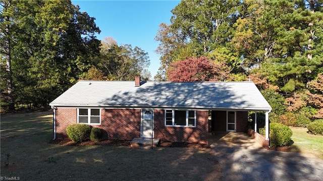 view of front of property with a front yard and a carport