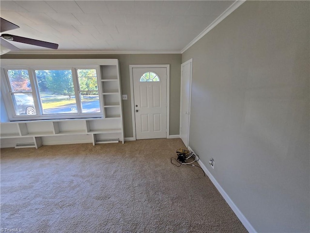 carpeted foyer featuring ceiling fan and ornamental molding