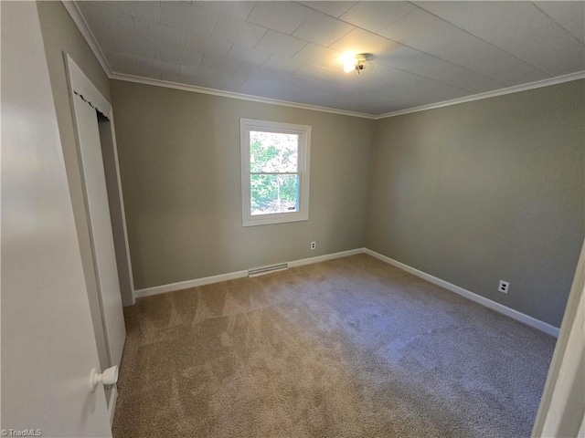 carpeted spare room featuring crown molding