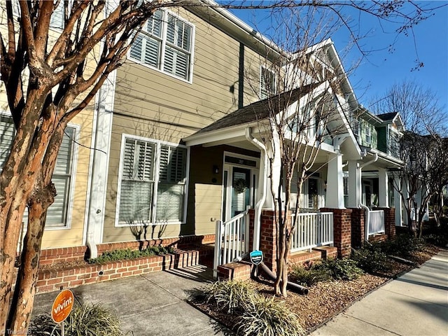 view of front facade featuring covered porch and brick siding