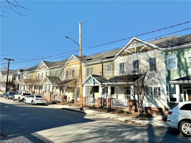 multi unit property with a residential view, a porch, and brick siding