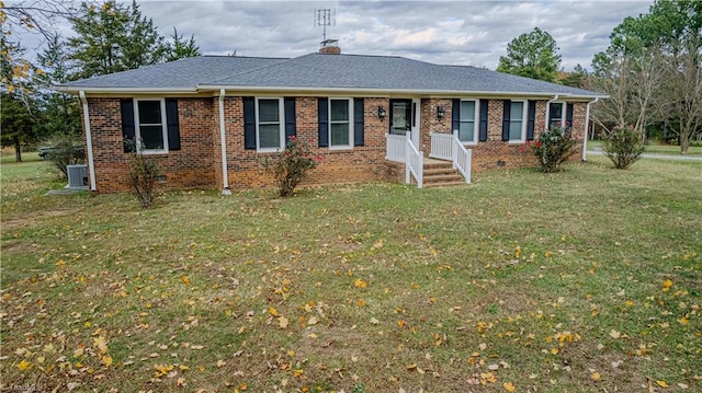 ranch-style house featuring central air condition unit and a front lawn