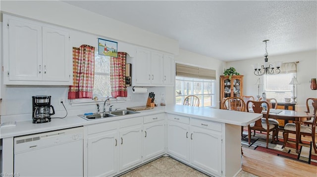 kitchen with dishwasher, plenty of natural light, sink, and kitchen peninsula