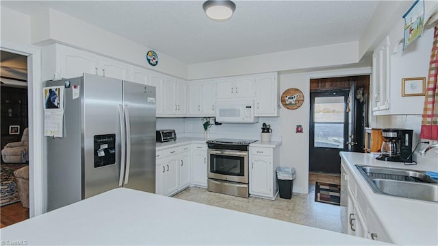 kitchen with appliances with stainless steel finishes, white cabinetry, and sink