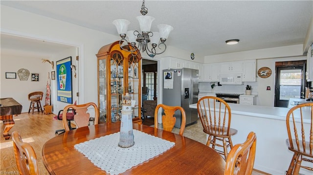 dining area with light hardwood / wood-style flooring and a chandelier